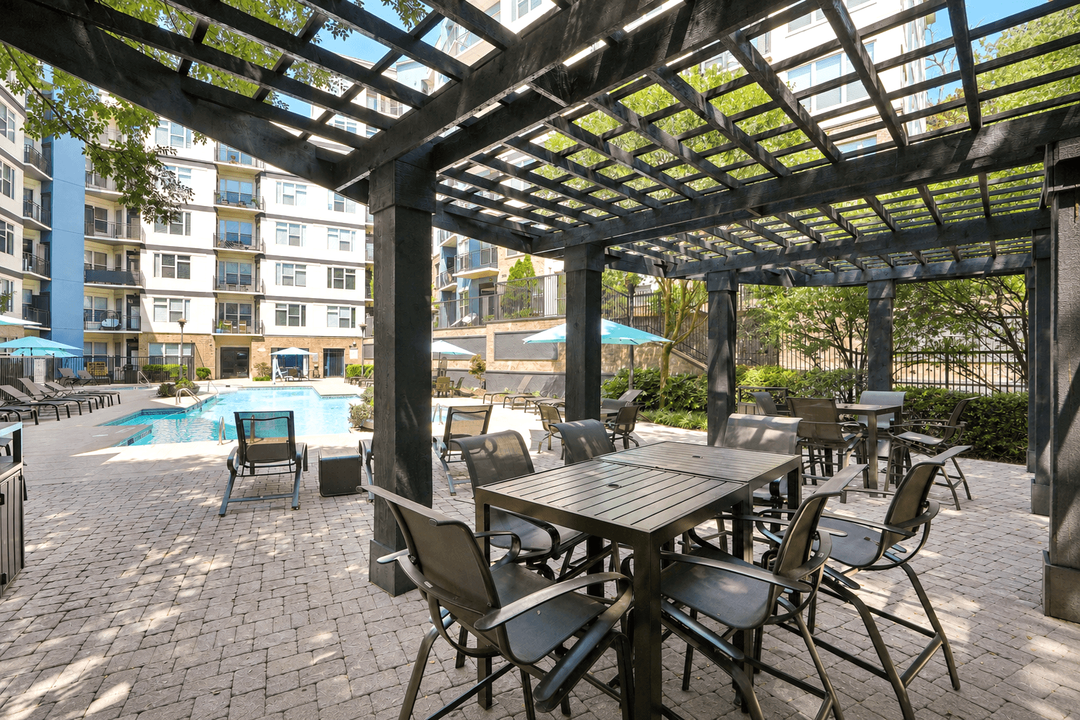 A patio with a table and chairs under a pergola.